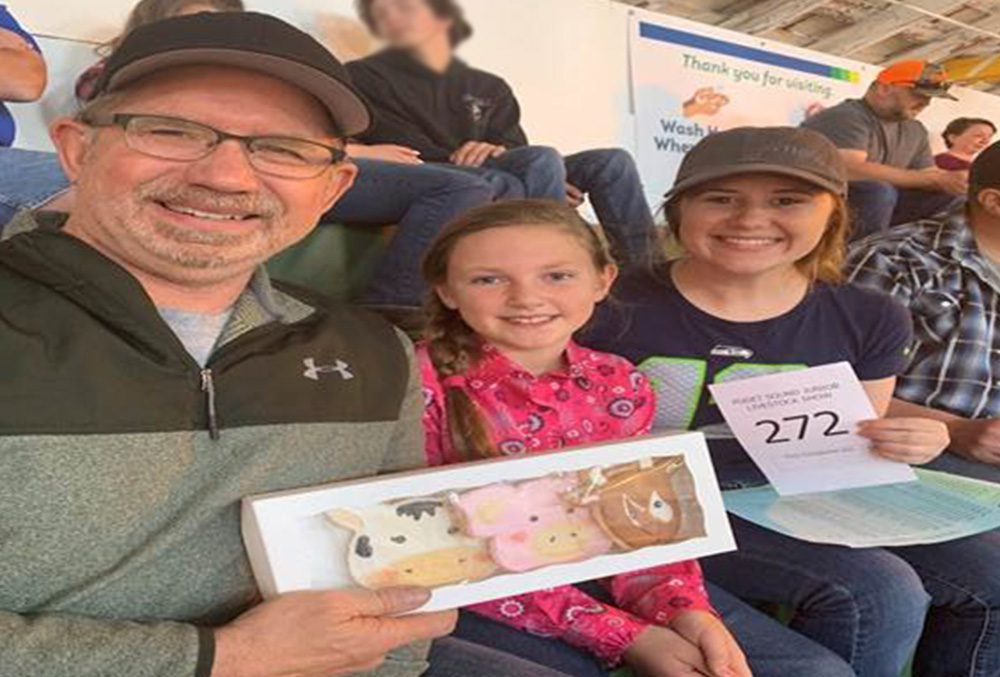 father and his daughters at a live stock fair